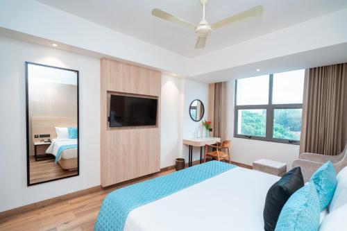 a hotel room with a large bed and a mirror at Metro park inn in Coimbatore