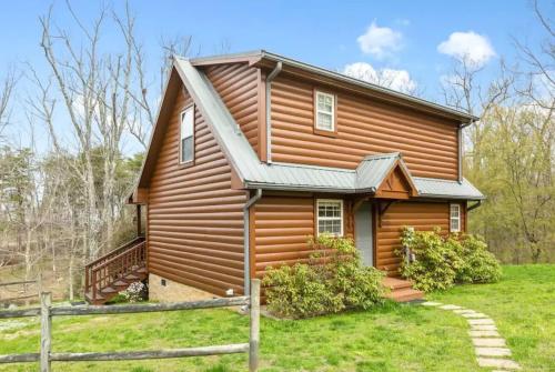 a log cabin with a porch and a fence at Mountain Hideaway at Cabins in the Clouds in Rising Fawn