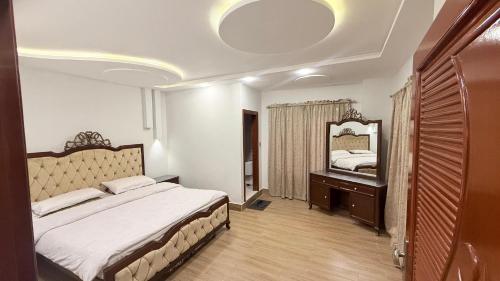 a bedroom with a bed and a large mirror at Shareef Lodge in Murree
