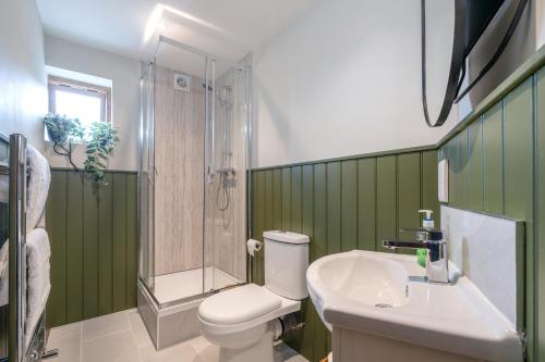 a bathroom with a toilet and a shower and a sink at Spacious Cottage in Dartmoor in Hennock