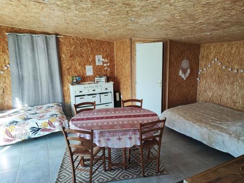 a room with a table and a bed and a bedroom at Studio des Mèzerets in La Chapelle-Engerbold