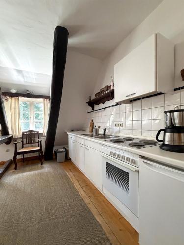 a kitchen with white cabinets and a stove top oven at Lieblingsnest in Bad Fallingbostel