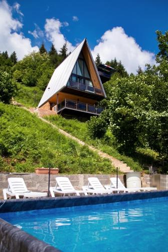 a group of lounge chairs in front of a house at Villa MERISI in Merisi