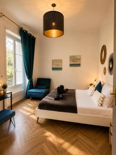 a teddy bear sitting on a bed in a bedroom at le Riviera in Aix-les-Bains
