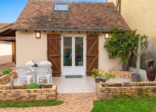 a patio with a table and chairs in front of a house at Charmant studio avec terrasse à Chenou, 20 m² in Chenou