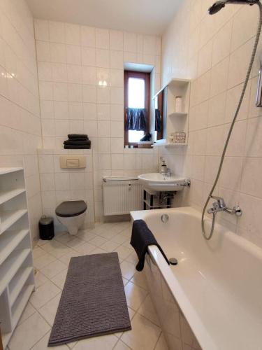 a bathroom with a tub and a toilet and a sink at NEU! Fereinwohnung Greim in Lengenfeld