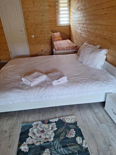 a bed with two towels on it in a room at Butoiașele Montesanto - Explora y Alegrate in Copalnic Mănăştur