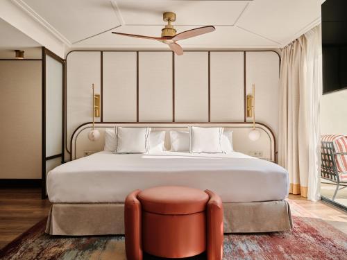 a bedroom with a bed with a ceiling fan and a stool at BLESS Ibiza The Site - New Opening 2026 in Playa d'en Bossa