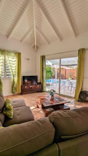 a living room with a couch and a table at Villa élégante à Saint-François + Piscine privée in Saint-François