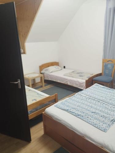 a room with three beds and a chair at Andrea Apartman in Siófok