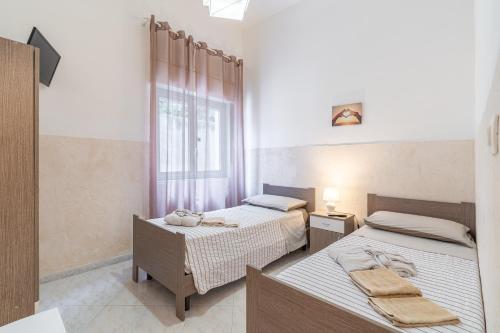 a bedroom with two beds and a window at Villa Anny Fronte Mare in Avola