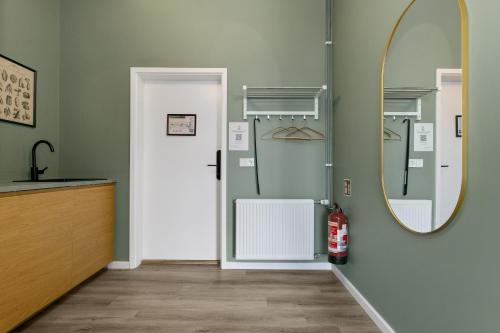a bathroom with a mirror and a door at ASKA Hraun in Hafnarfjörður