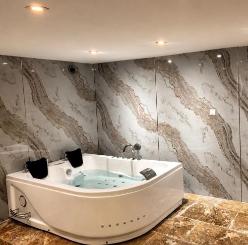 a jacuzzi tub in a room with wallpaper at Suite avec jacuzzi DOLCE NOTTE in Rochegude