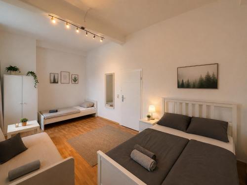 a bedroom with a large bed and a couch at City Rooms Koblenz Hbf in Koblenz