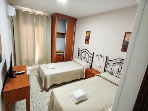 a small room with two beds and a desk at H Arkanta in Arganda del Rey