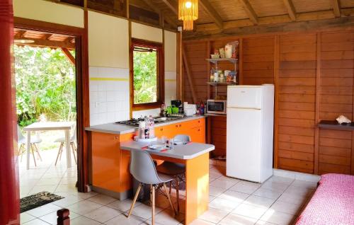 a kitchen with a white refrigerator and a table at Bungalow charmant au Gosier in Le Gosier