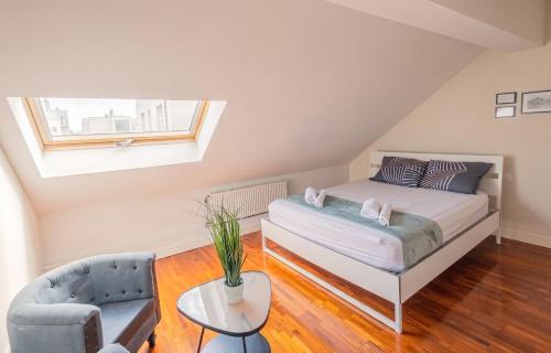 a attic bedroom with a bed and a chair at Spacious House with Large Garden in Jette in Brussels