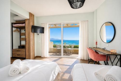 a bedroom with two beds and a desk with a view of the ocean at Villa Alora in Barbati
