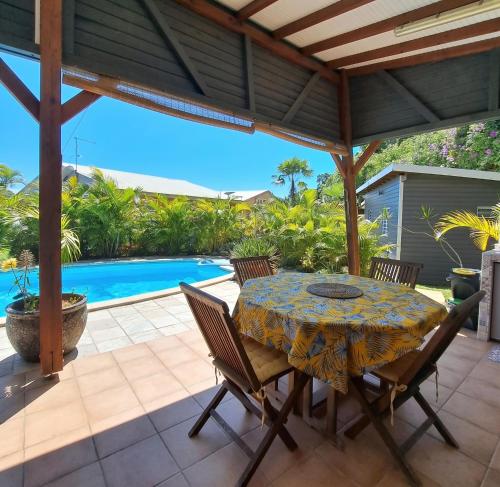 a patio with a table and chairs and a pool at Villa cosy avec piscine privée - Le Gosier. in Le Gosier