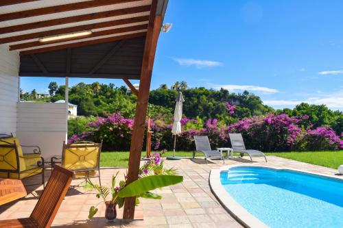 a patio with chairs and a swimming pool at Villa cosy avec piscine privée - Le Gosier. in Le Gosier