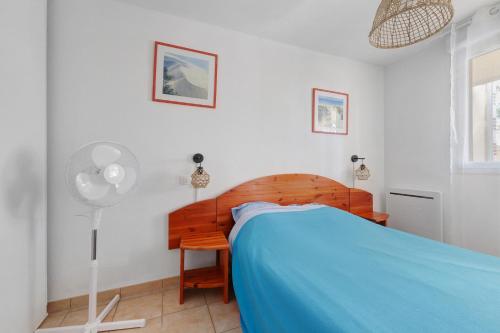 a bedroom with a bed and a desk and a fan at Appartement chez Coco avec piscine in Soulac-sur-Mer
