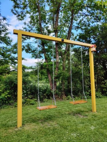 two swings in a park with trees in the background at Villa Harmony Tianeti in Tʼianetʼi