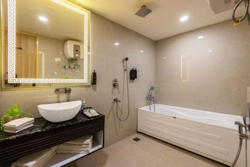 a bathroom with a sink and a tub and a mirror at Hotel The Venue At Delhi Airport IGI in New Delhi
