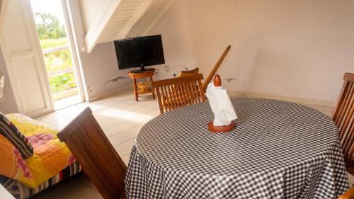 a dining room with a table and a tv at Appartement confortable à Capesterre, 40 m², jardin agréable in Rabi