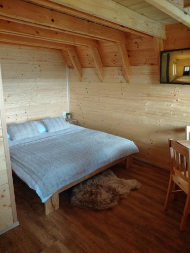 a bedroom with a bed in a wooden cabin at Glamping Čelig in Donja Višnjica