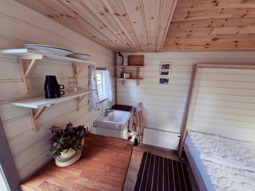 a small bathroom with a sink in a tiny house at Sandvikengården Stugby in Edane