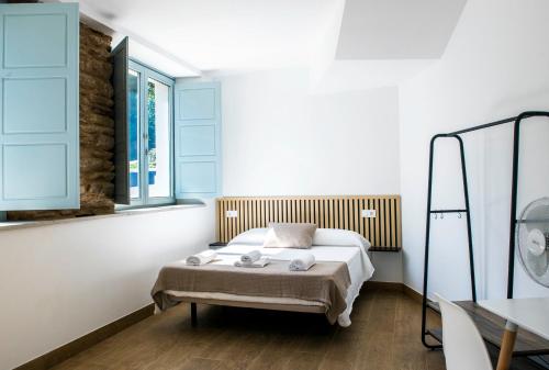 a bedroom with a bed and a window at A Calexa Sarria nº1 in Sarria