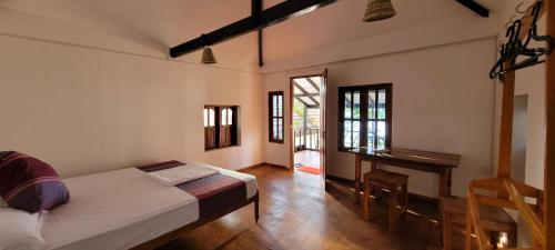 a bedroom with a bed and a desk in it at Galaxy Lounge in Arugam Bay