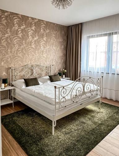 a bedroom with a white bed with a wall at Alexandra Nesvady in Nesvady