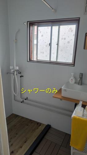 a bathroom with a sink and a window at 海辺の宿錦 b in Tomakomai