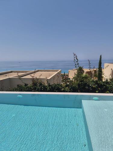 a swimming pool with a view of the ocean at Vila IL SOLE GREEN COAST in Palasë