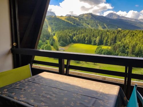 a bench in a room with a view of a mountain at Studio avec vue sur la montagne à Villard de Lans - 34 m² in Villard-de-Lans