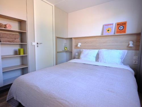 a bedroom with a large white bed and shelves at Blendin Retreat Agde in Le Grau-dʼAgde