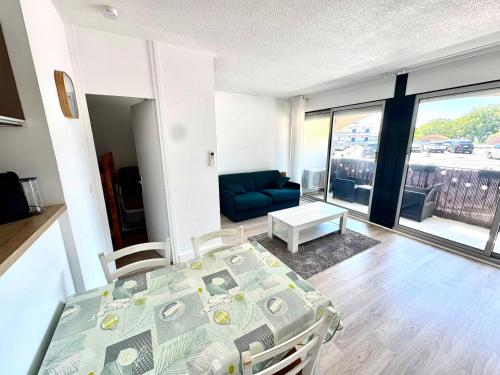 a room with a bed and a living room with a couch at Reflet d’Azur - 4 personnes - Point zéro in La Grande Motte