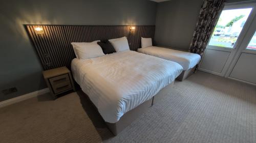 a hotel room with two beds and a window at Canavans Hotel in Garvaghy