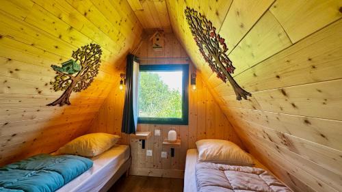 a room with two beds in a log cabin at LES CHALETS DE COYRON. in Coyron