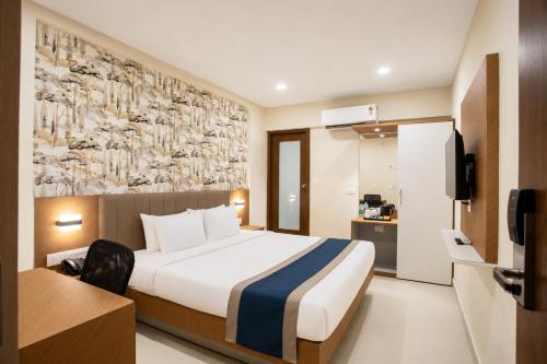 a hotel room with a bed and a tv at Hotel Eagle Empire in Madgaon