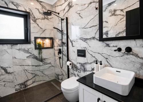 a bathroom with a white toilet and a sink at Grey Stones Villa by HolidayKeys in Kyrenia