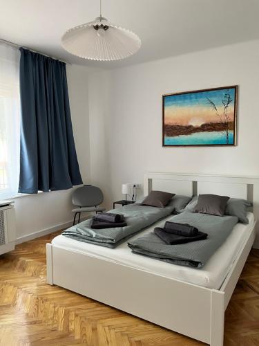 a large white bedroom with two beds in it at Pelso d'Oro apartmanház in Balatonföldvár