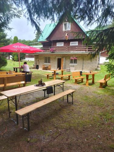 a group of picnic tables in front of a building at Grizzly Krpáčovo in Dolná Lehota