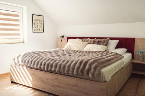a bedroom with a large bed with a wooden frame at Domki pod Krakowem - Stare Sady in Kopytówka