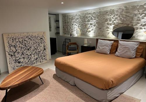 a bedroom with a large bed and a table at DURANCE in La Brillanne
