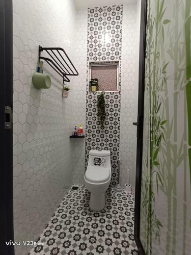 a bathroom with a toilet with a black and white tiles at HANS HOMESTAY in Lumut
