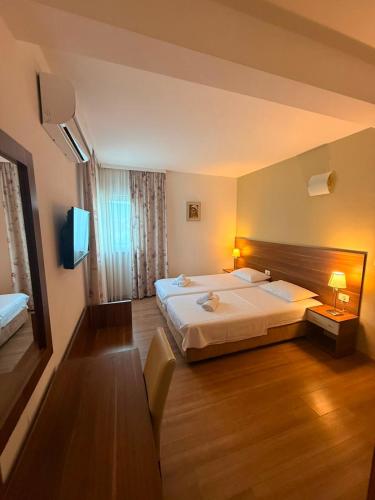 a hotel room with a large bed and a television at Hotel BlueTwo Međugorje in Međugorje