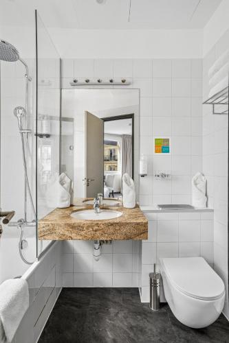 a white bathroom with a sink and a toilet at Excelsior Opera in Paris