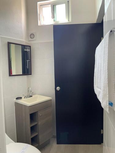 a bathroom with a black door and a sink at Apartment with Pool & Gym in Querétaro